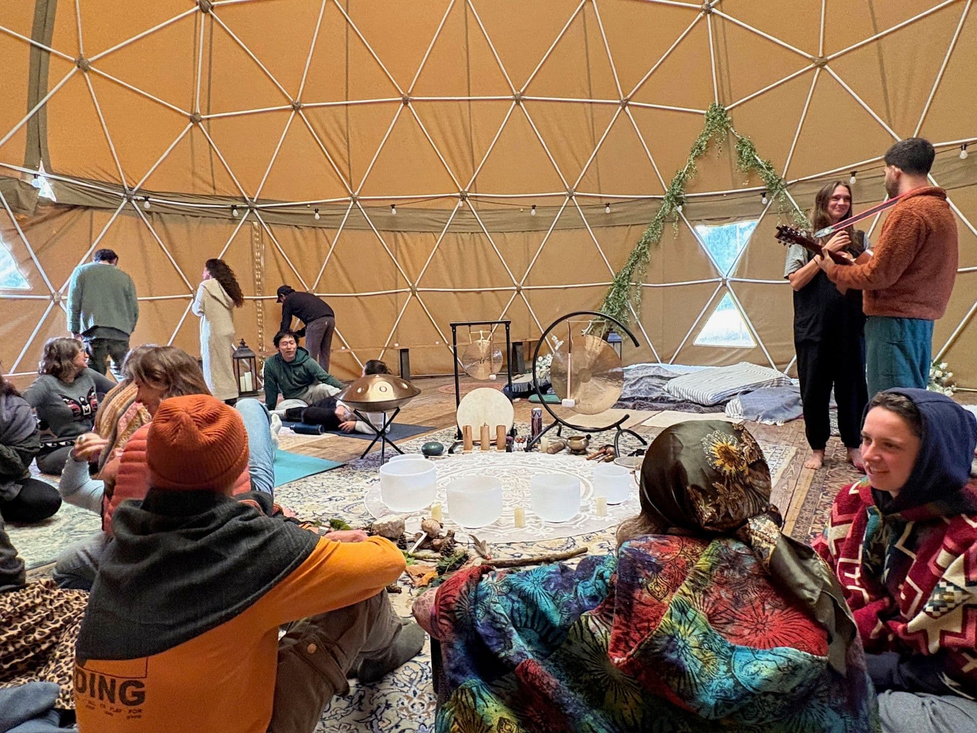 Inside a geodesic dome with live music and seated circle